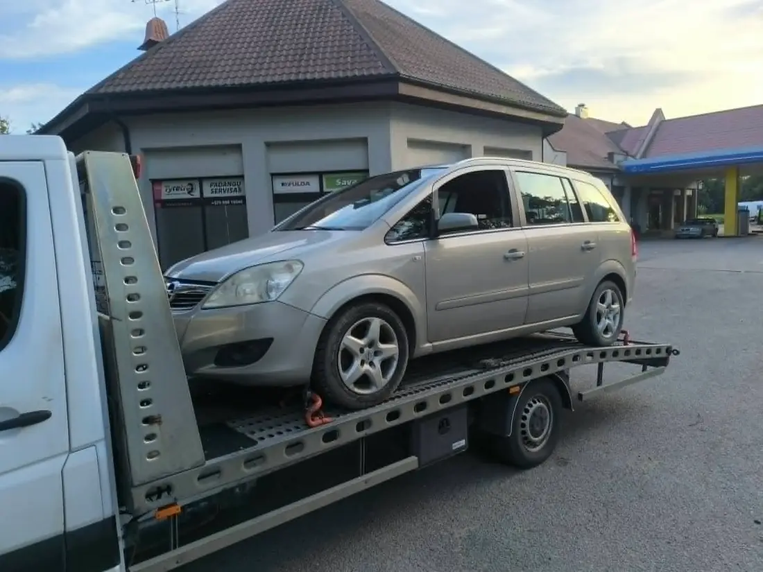 Nevažiuojantis automobilis vežamas traliuku